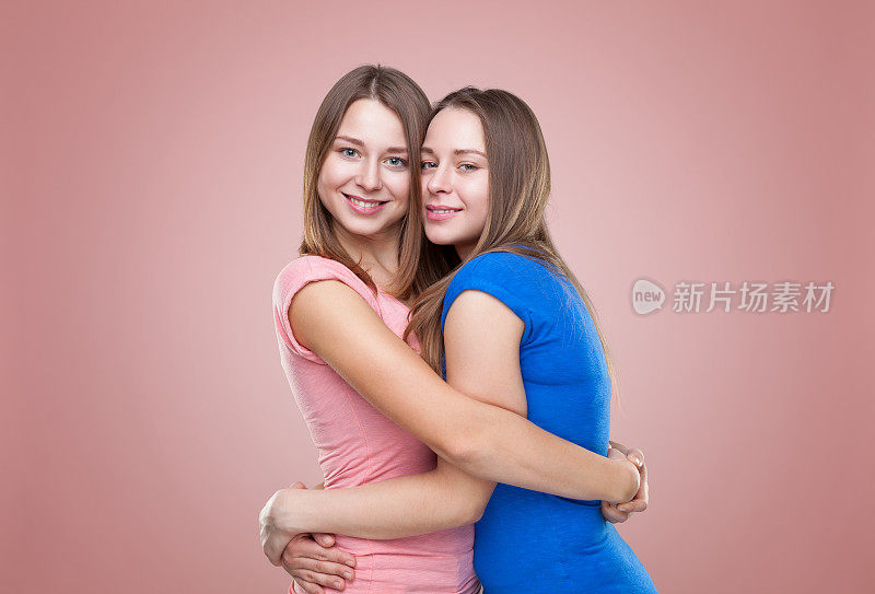 一对双胞胎姐妹拥抱在一起的照片
