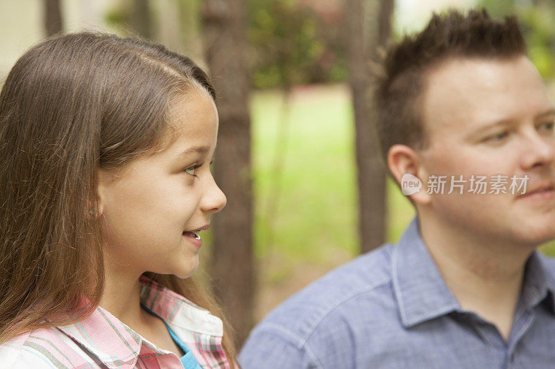 父亲和女儿在户外的特写。春天或夏天的后院。