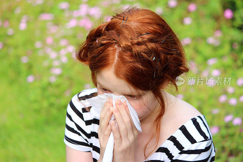 花园里的女孩得了花粉病，擤鼻涕，打喷嚏，过敏
