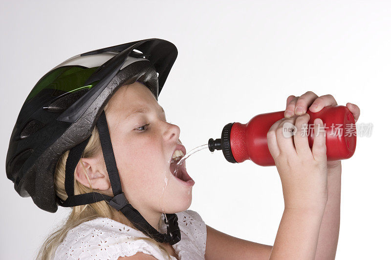 骑自行车的人用水瓶喝水