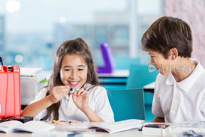 兴奋的小学生在科学课上使用机器人套件