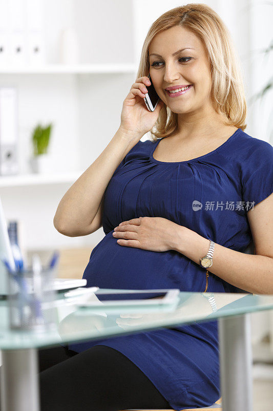 孕妇女商人用智能手机聊天