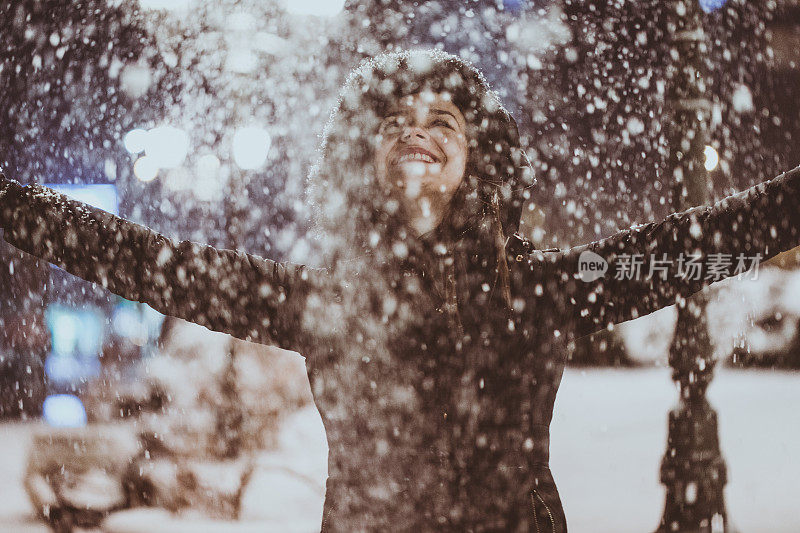 女孩在城里享受第一场雪