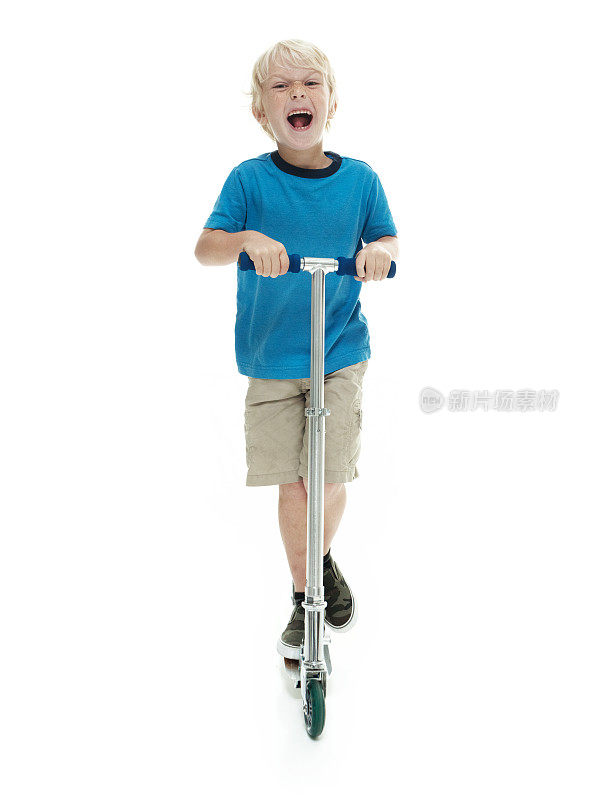 兴奋的小男孩骑着滑板车