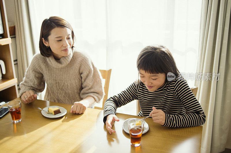 母亲和女儿一起在房间里吃Castella