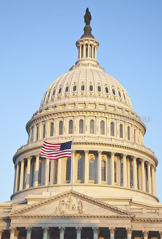 日出时的美国国会大厦圆顶和国旗