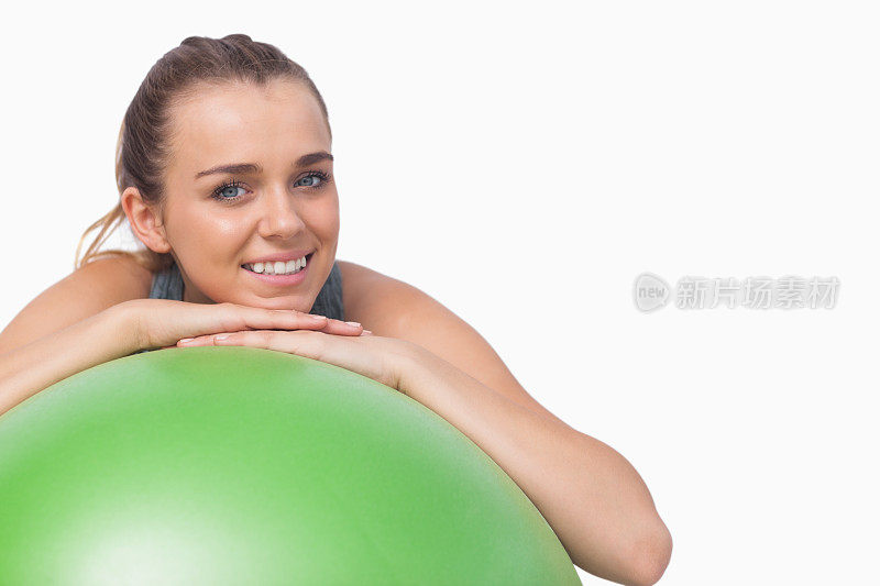 运动美女用健身球支撑自己