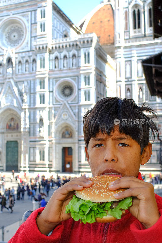 男性幼儿吃垃圾食品。意大利佛罗伦萨的圆顶。