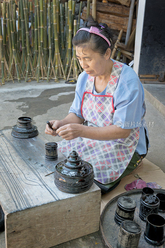 女人使漆器