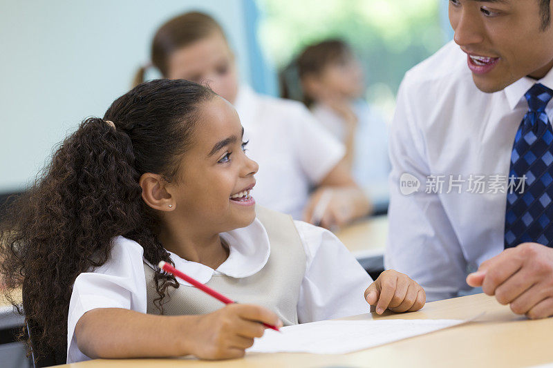 可爱的小学女孩和老师在私立学校的教室