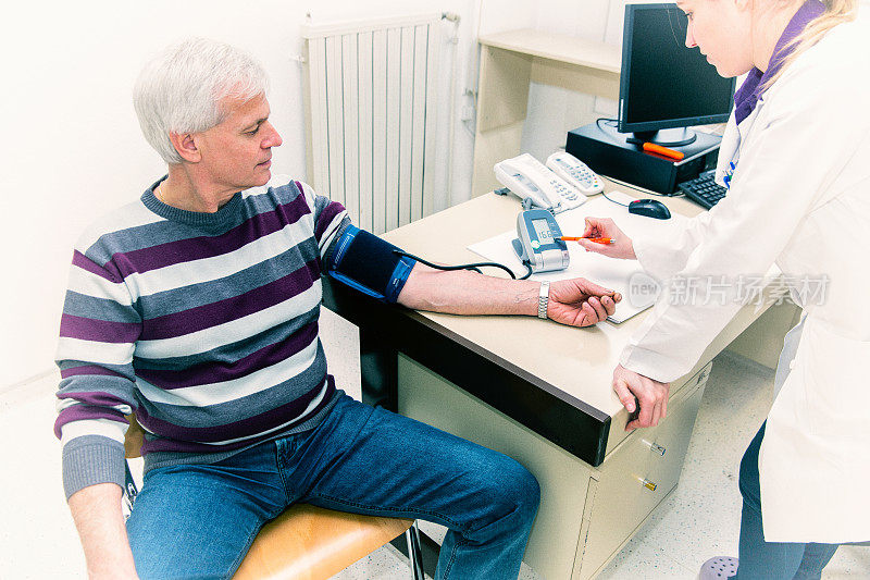 可爱的女医生给老病人测量血压