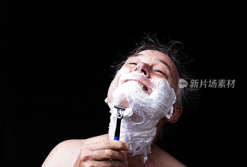 男子用一次性剃须刀刮湿胡须