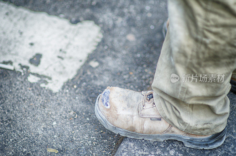 室外街道上肮脏的施工靴