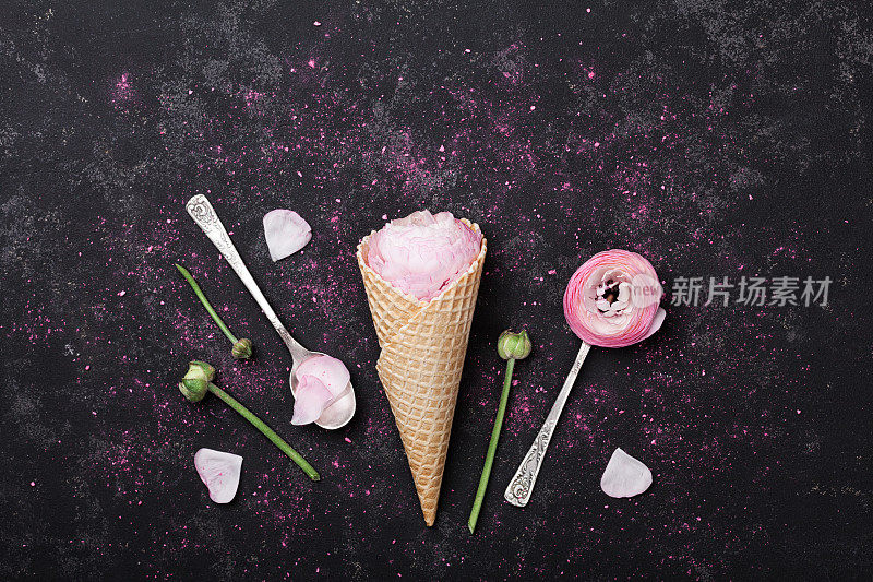 创意花卉组成。华夫蛋筒里的粉红色毛茛花冰淇淋。平的。复古风格。