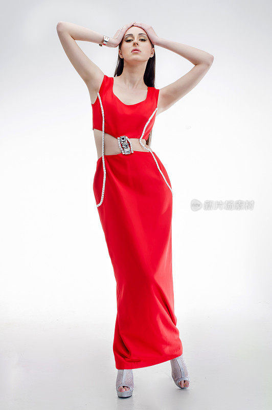 年轻的时装模特穿着时髦的红色连衣裙