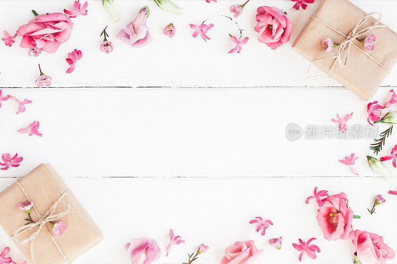白色木质背景上的礼物和粉色花朵