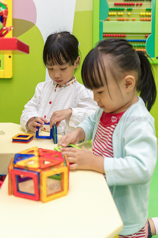 亚洲华人小女孩玩彩色磁铁塑料积木套件