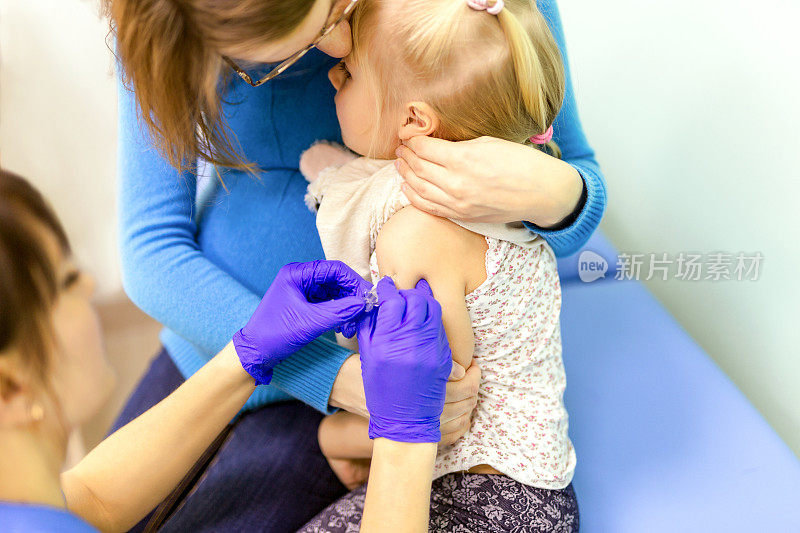 医生用注射器给孩子接种疫苗
