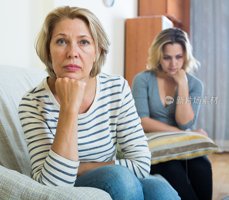 心烦意乱的年轻女子和年长的母亲在室内有不好的争吵