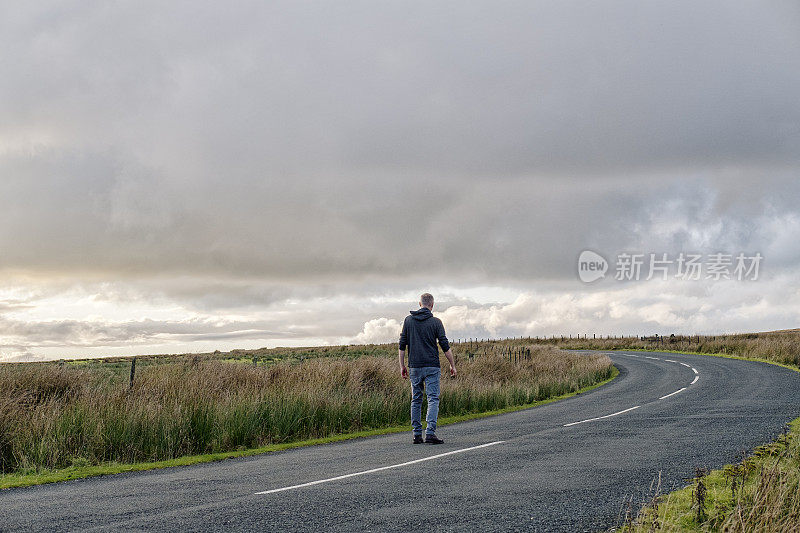 一个人走在乡间小路上。