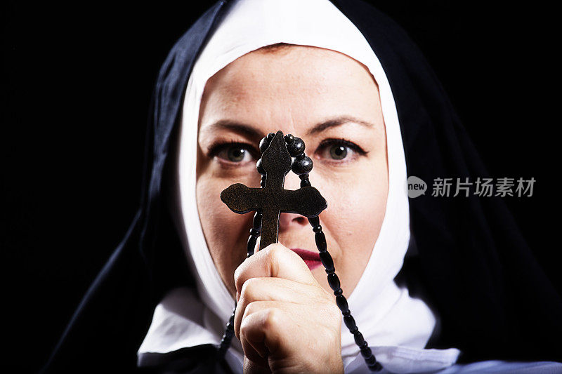 修女把一个十字架举在面前