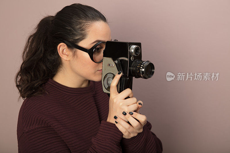 戴着大眼镜的女人，拿着老式胶卷相机