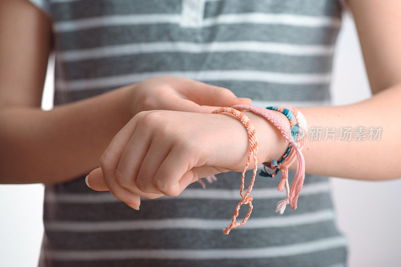 水平色调的照片，一个女性的手戴着编织手镯