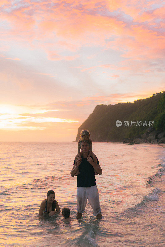 父亲和女儿们在巴厘岛的海滩上玩耍