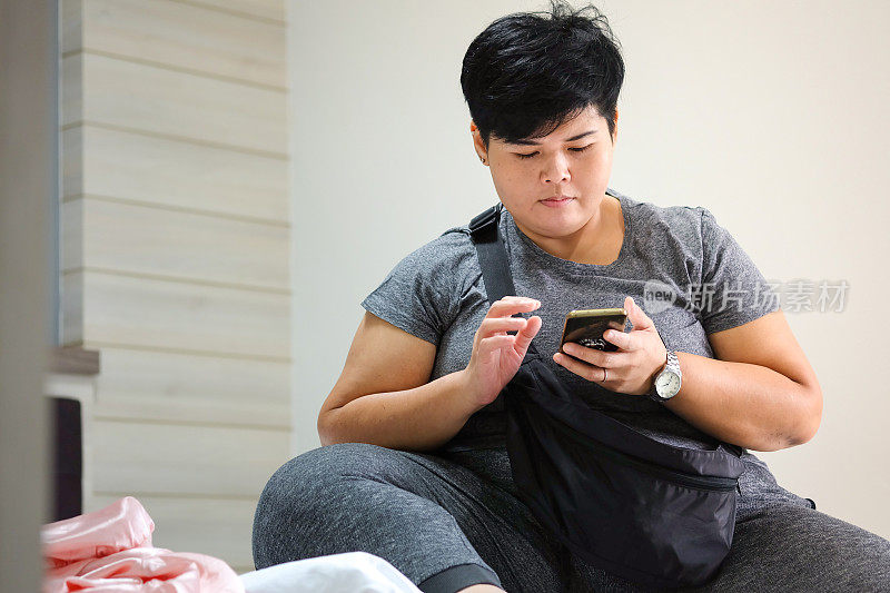 亚洲女性沉迷于玩平板电脑和手机，沉迷于社交网络