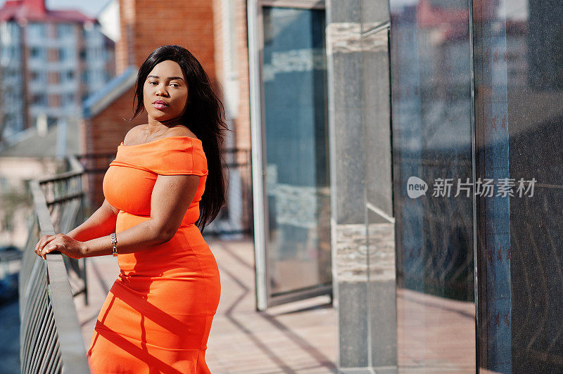 非裔美国女模特xxl穿橙色的衣服。