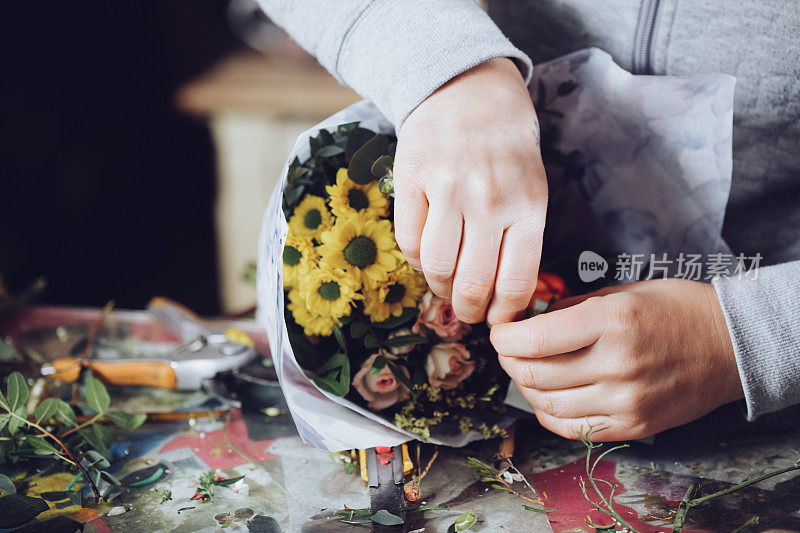 现代花匠工作与鲜花在车间-与手的细节