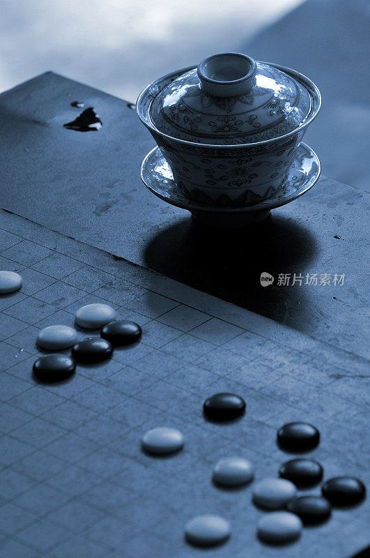 传统的中国茶壶和石头在一个围棋板