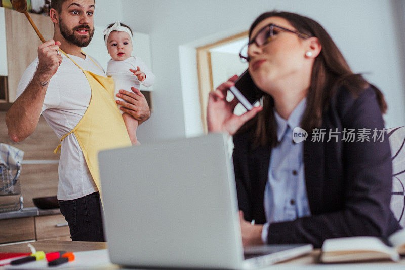 女人在工作，男人和他的女儿在厨房做饭