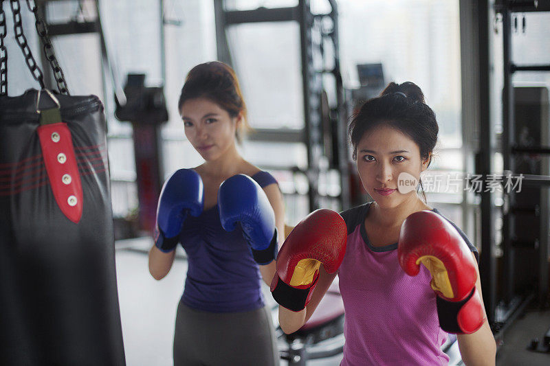 中国妇女戴着拳击手套在健身房