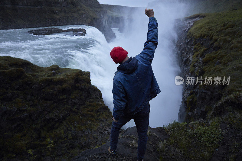 自然美。旅行欣赏瀑布。张开双臂