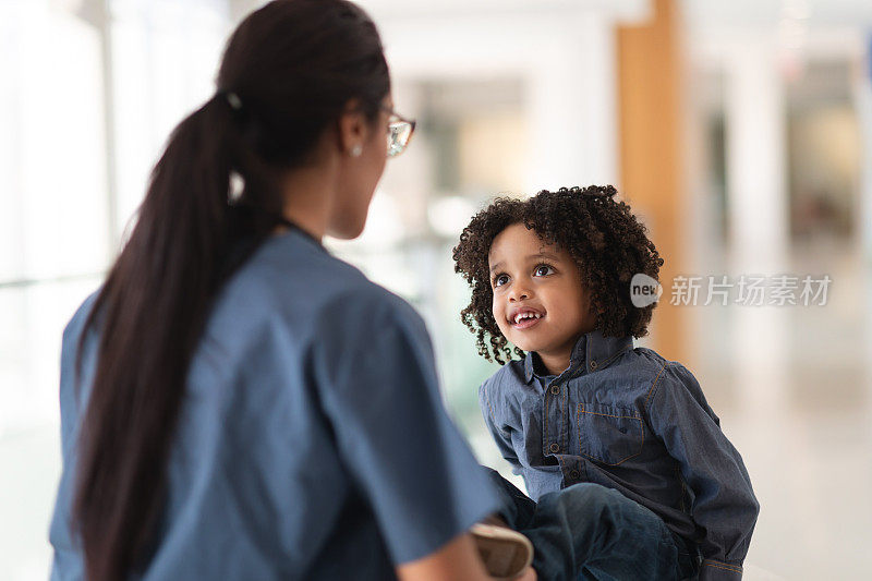 女医生安慰她蹒跚学步的病人