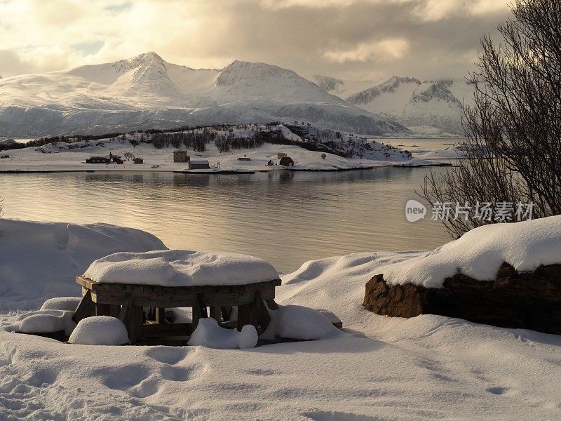 冬天，北极海湾前的长凳上有雪