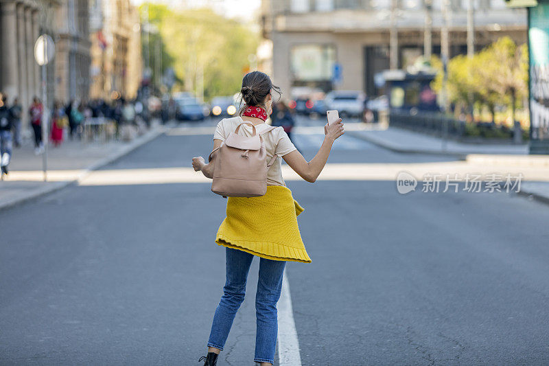 一个快乐女人的肖像。走在城市道路上的年轻女子。快乐的年轻成年妇女微笑着牙齿在户外和走在城市的街道上。