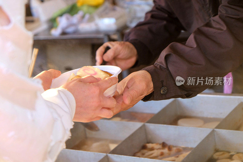 游客在街头市场购买日本优冬