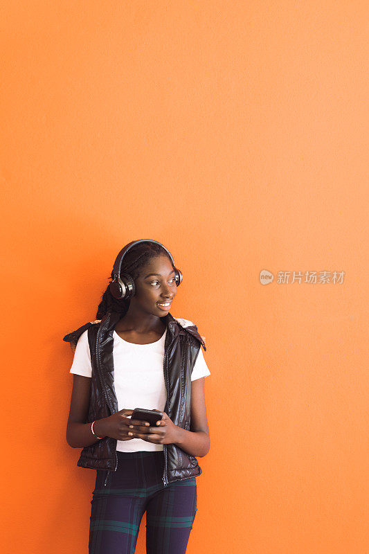 非洲裔澳大利亚少女戴着耳机听音乐