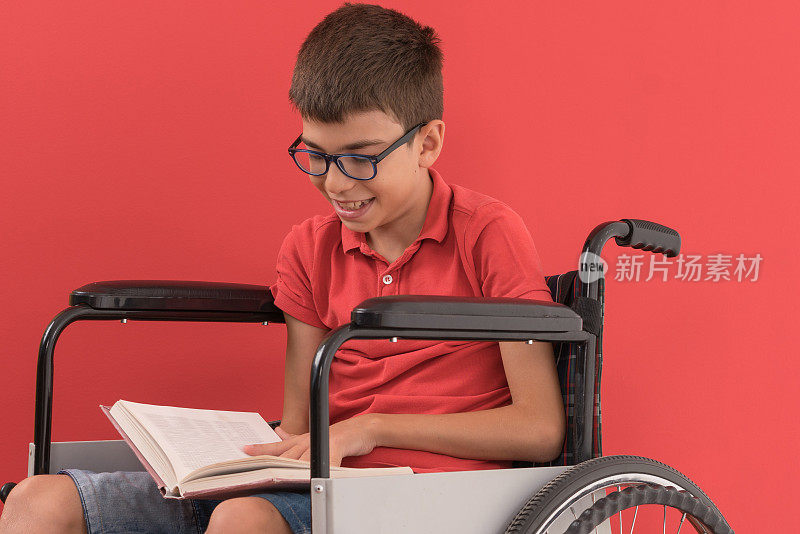 残疾男孩在轮椅上看书