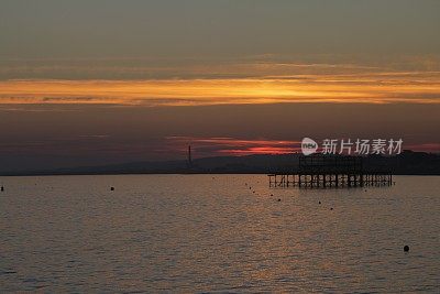 布赖顿西码头与戏剧性的日落天空在海上和城市沿海天际线布赖顿，东苏塞克斯，英国，从布赖顿码头，布赖顿海滩的黄昏照片