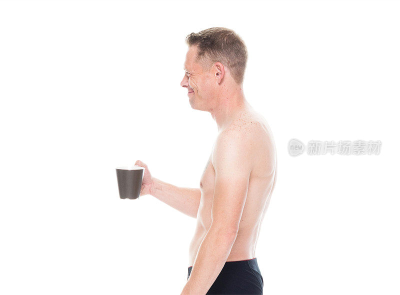 一个穿着内衣的男人拿着一个咖啡杯