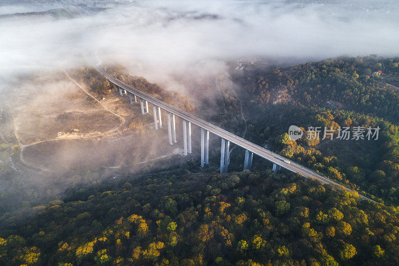 高架桥上的高速公路鸟瞰图，高科技工程建设，赭色的景观和天空中的低云。