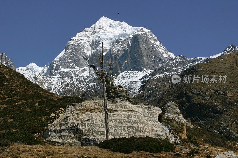 西藏人在白雪皑皑的山石上祈祷