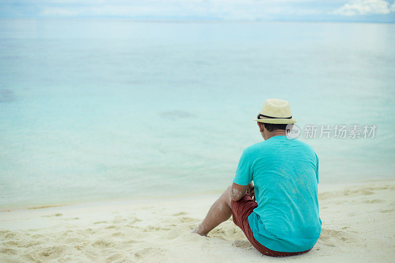 一个男人坐在海滩上