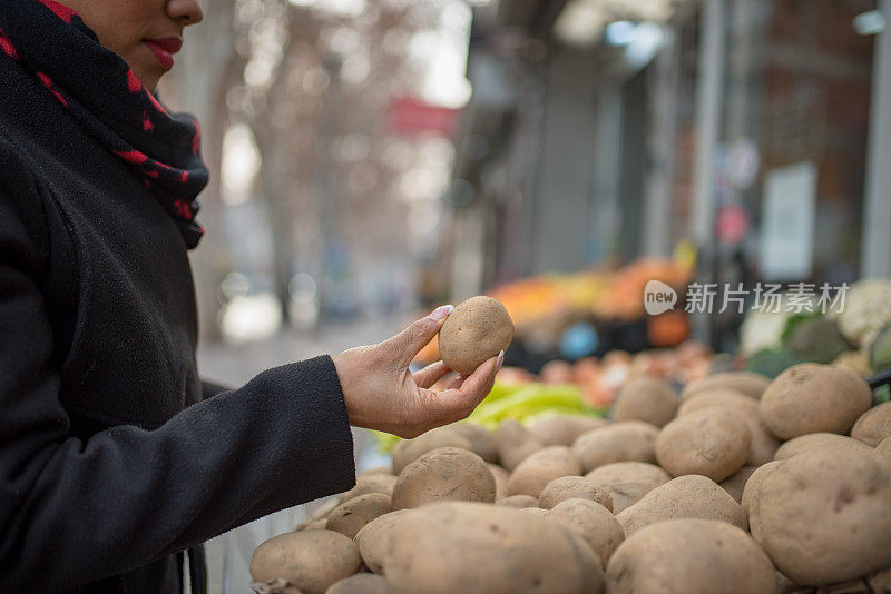 肤色不同的妇女在传统市场挑选蔬菜