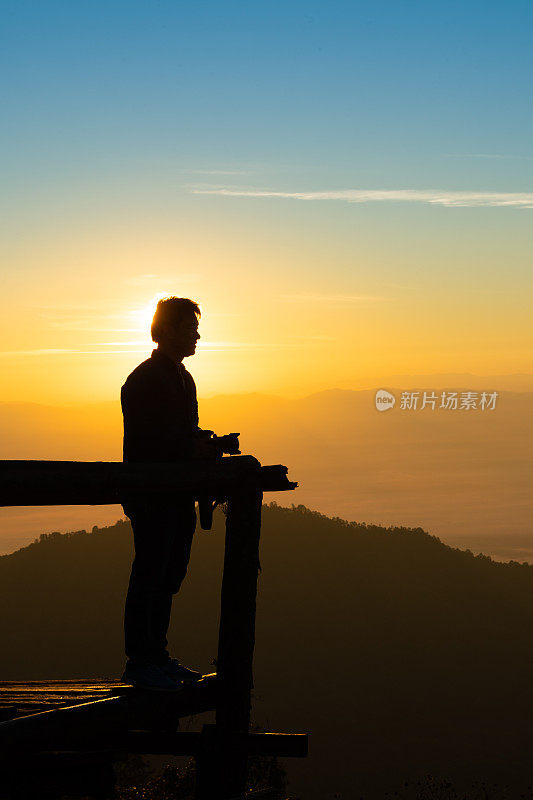 一名年轻人在泰国北部的吴康清迈自然景观日出景区用相机拍照