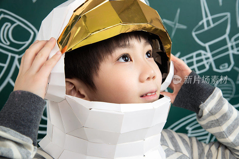 戴着航天员头盔的小男孩站在黑板前