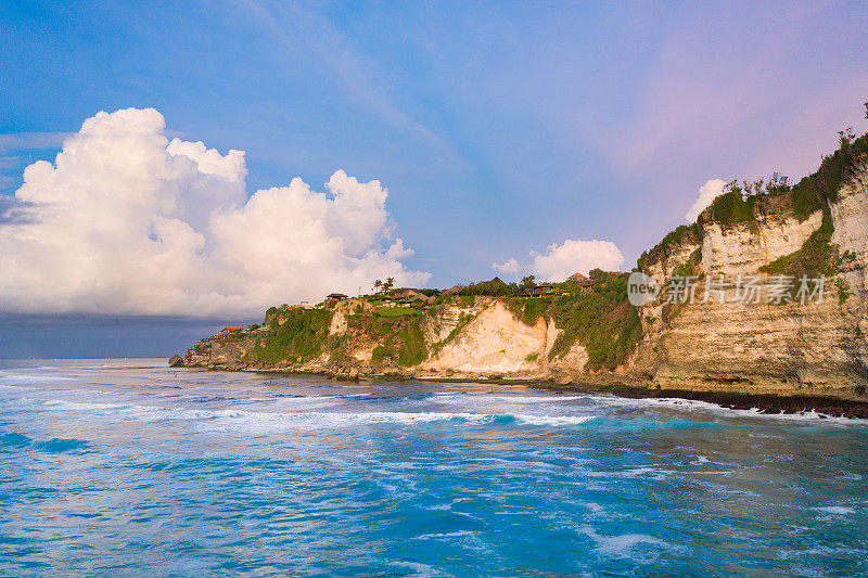 Uluwatu巴厘岛。蓝色的海洋和岩石山，覆盖着热带树木。